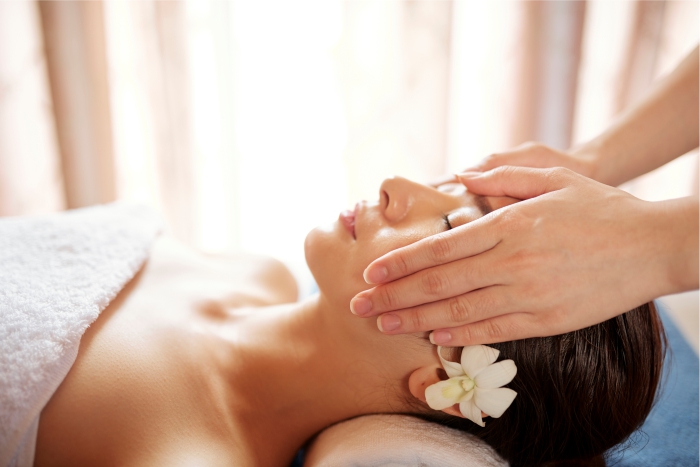 Mulher recebendo massagem terapêutica com óleo de semente de uva.